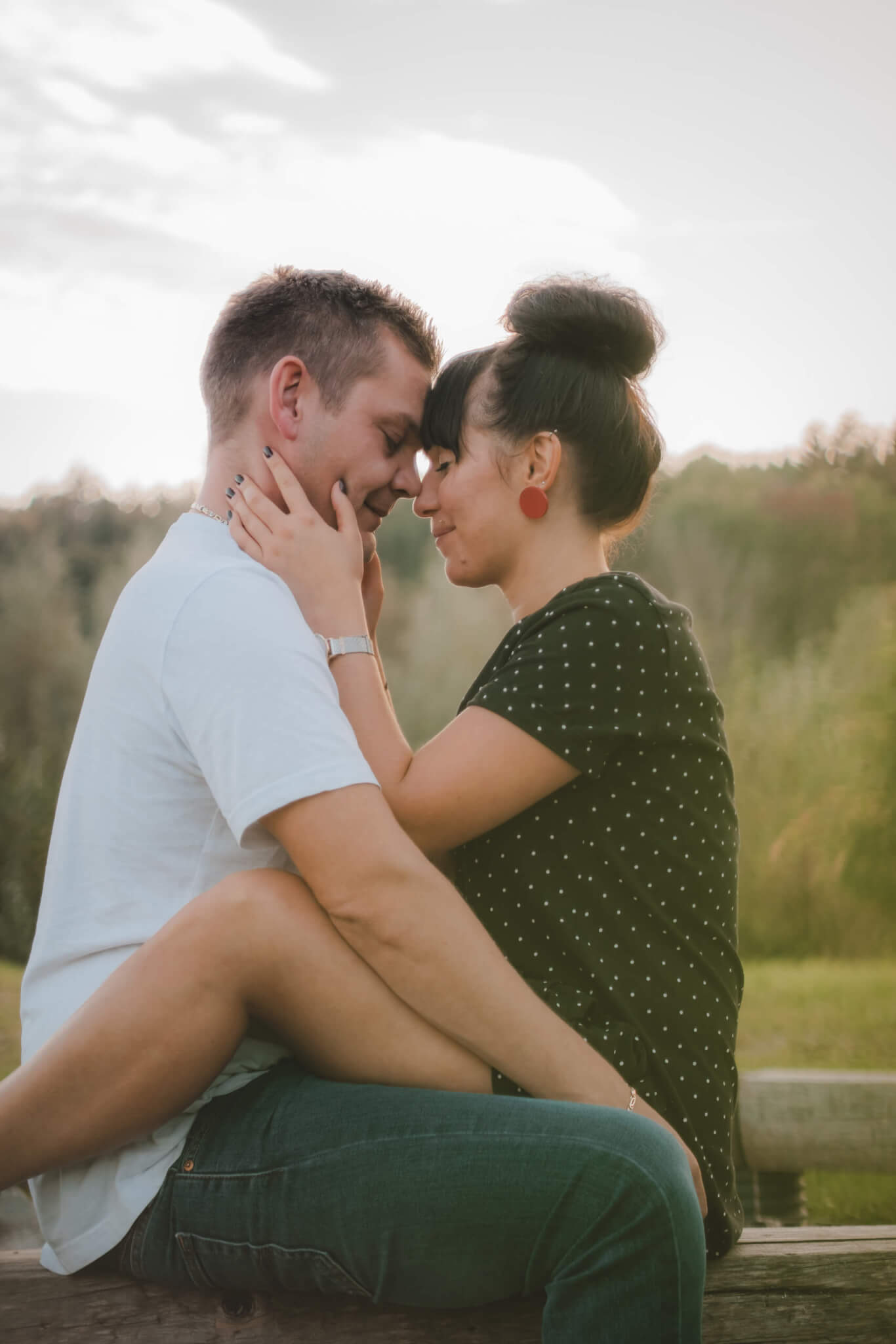 Paar in inniger Umarmung bei Sonnenuntergang im Freien, Ausdruck von Liebe und Romantik in der Natur.