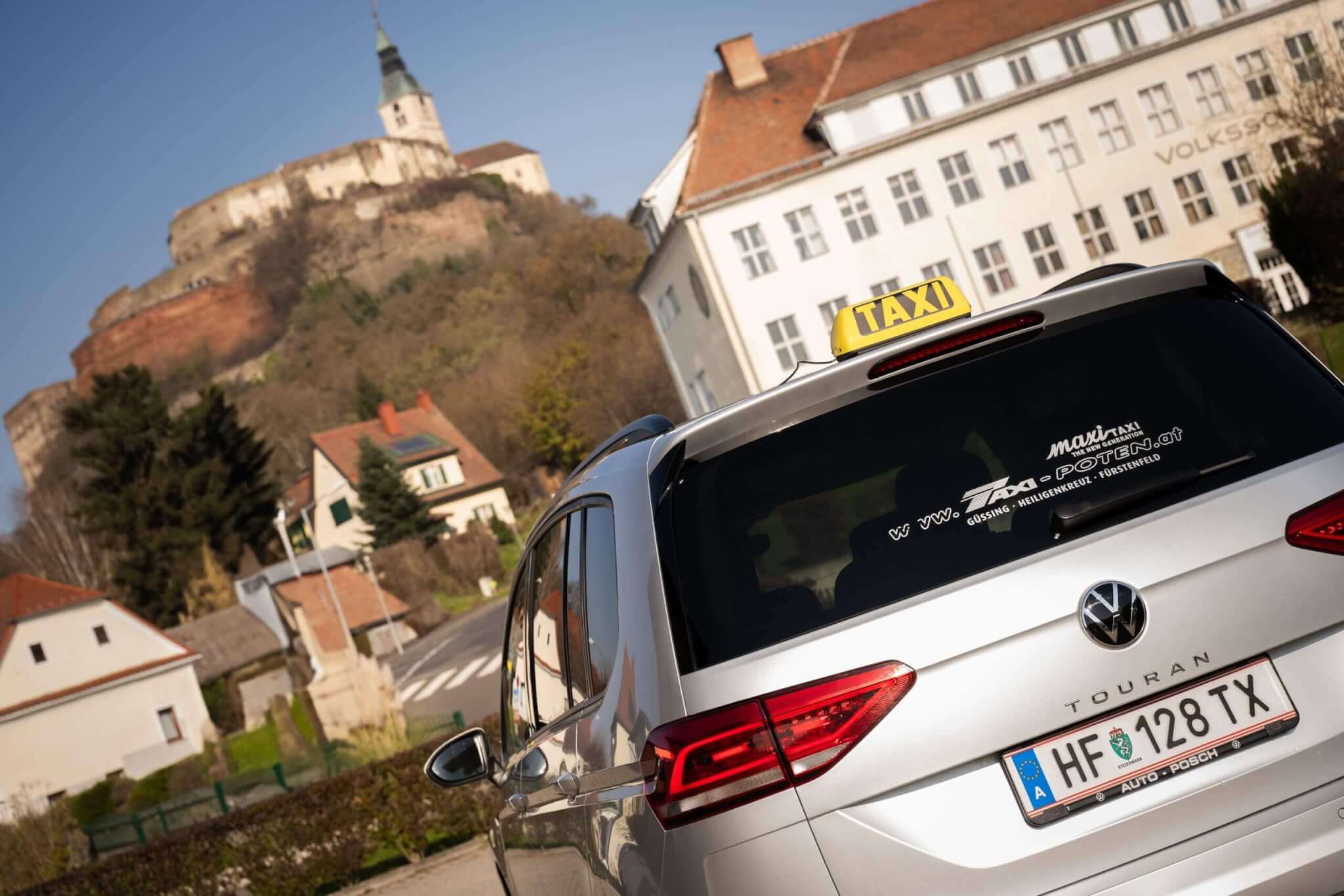 Silbernes Taxi mit Schloss im Hintergrund, ideal für Touren durch malerische Umgebungen.